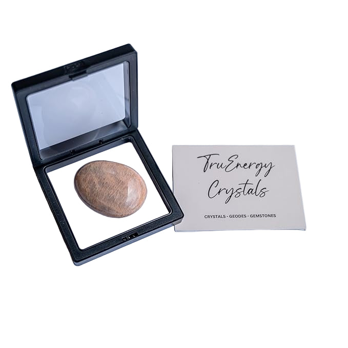 Open black crystal case with a stone inside on a white background, next to a 'TruEnergy Crystals' card.