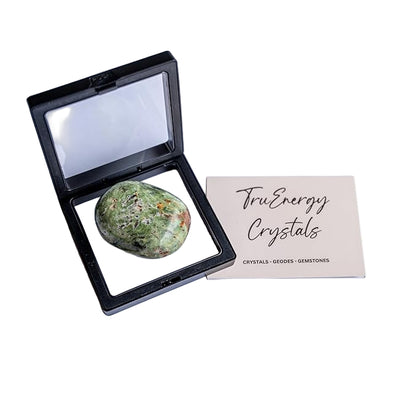 Green crystal stone in a black display case with 'TruEnergy Crystals' card on a white background