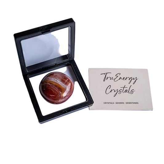 Polished stone in a display case with 'Tru Energy Crystals' card on a white background