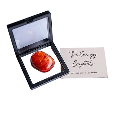 Orange crystal in a black display case with 'TruEnergy Crystals' card on a white background