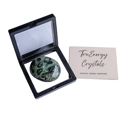 Green crystal stone in a black display case with 'Tru Energy Crystals' card on a white background